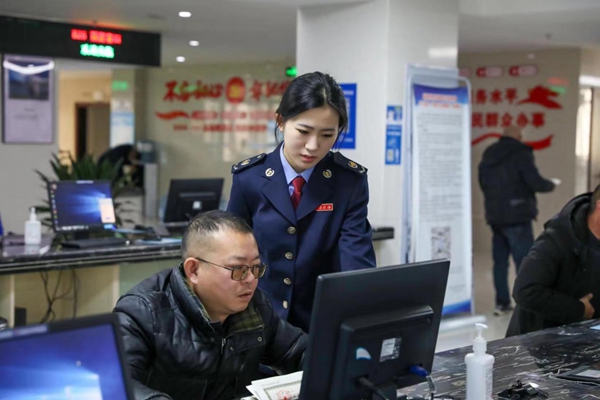 在梁平區(qū)辦稅服務(wù)廳電子稅務(wù)局辦理專區(qū)，稅務(wù)人員輔導(dǎo)企業(yè)辦稅人員線上辦稅。唐曉敏攝