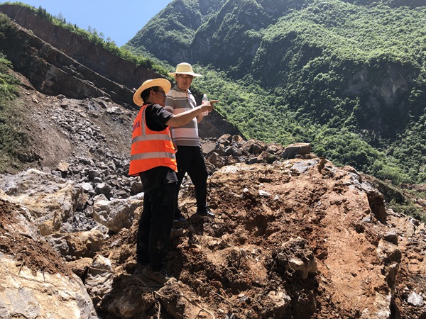《身先士卒》。巫溪縣滑坡?lián)岆U(xiǎn)工作中，炎炎烈日下 ，重慶市規(guī)劃和自然資源局地勘處處長(zhǎng)李少榮（右）與208地質(zhì)隊(duì)專業(yè)總工蔣先念現(xiàn)場(chǎng)討論滑坡?lián)岆U(xiǎn)方案。黎中余攝