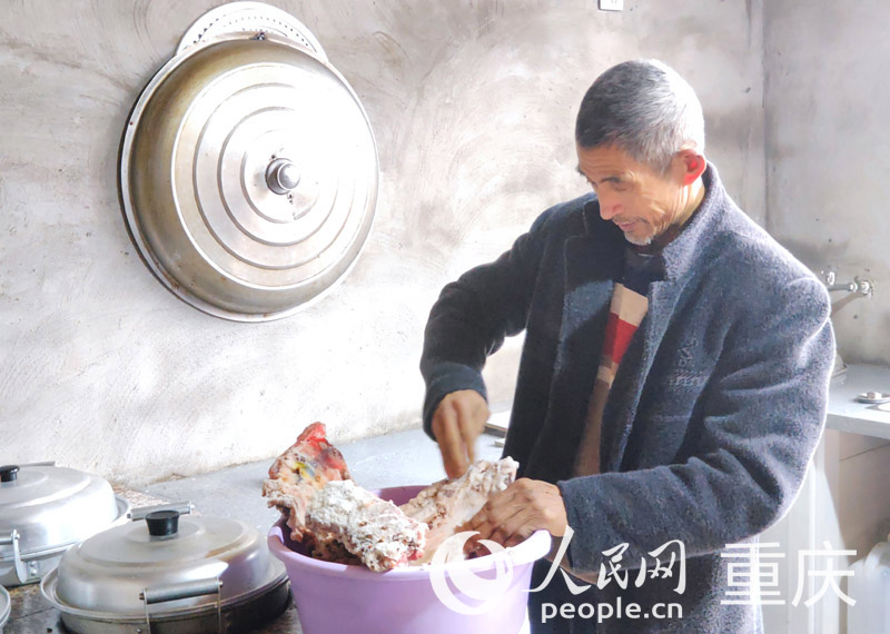 佘中華在新家廚房制作腌肉。人民網(wǎng) 陳琦攝