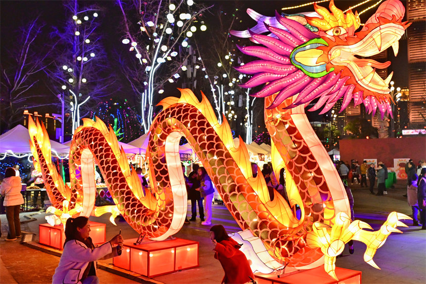 游客在南岸區(qū)南濱路鐘樓廣場賞燈拍照。郭旭攝