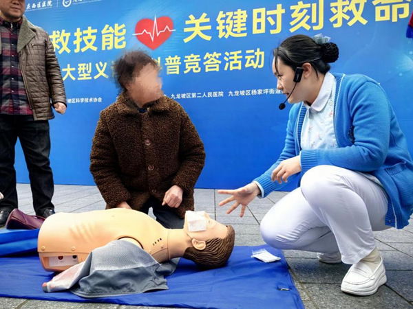 重慶西區(qū)醫(yī)院心臟血管疾病中心護理骨干譚彩虹指導市民學習心肺復蘇急救。重慶西區(qū)醫(yī)院供圖