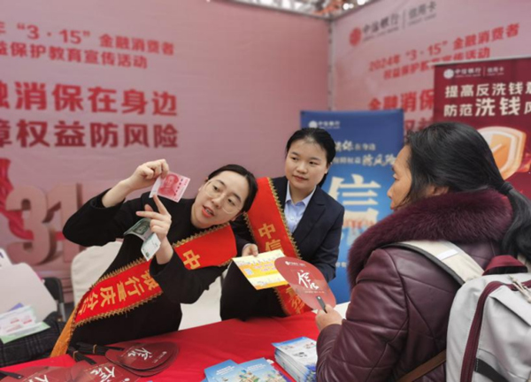 工作人員向消費者講解如何識別假幣。中信銀行重慶分行供圖