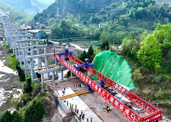 萬開達(dá)高速公路項(xiàng)目寨子坡大橋完成首片T梁架設(shè)。王長宇攝