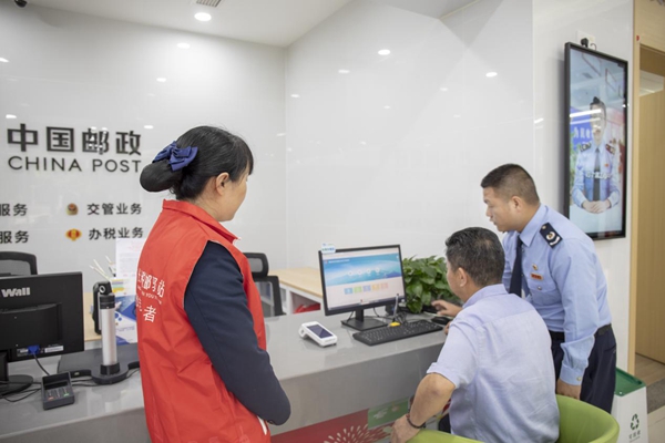 在長壽區(qū)“稅郵驛站”便民辦稅繳費點，特約監(jiān)督員正在體驗發(fā)票代開、社保費繳納等電子稅務局輔導服務。萬毅攝