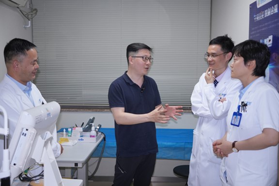 何勇（左二）與醫(yī)生探討科AI的應用。重慶普瑞眼科醫(yī)院供圖