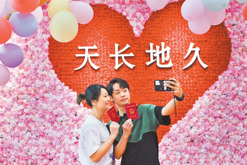 5月20日，渝北區(qū)婚姻登記處，新人正在拍照留影。當(dāng)日，在該婚姻登記處，一對對新人排起了長隊?；橐龅怯浱幉扇‰娫掝A(yù)約、增加結(jié)婚登記窗口等舉措，保障結(jié)婚登記工作的順利開展。首席記者 龍帆 攝/視覺重慶