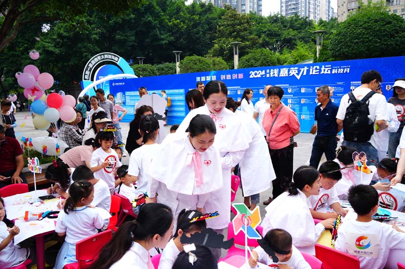 在醫(yī)護(hù)人員及家長帶領(lǐng)下，小朋友們圍繞控?zé)熤黝}畫畫。實習(xí)生趙鑫攝