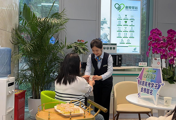 “郵愛(ài)驛站”工作人員為送考家長(zhǎng)端上熱水。郵儲(chǔ)銀行重慶分行供圖