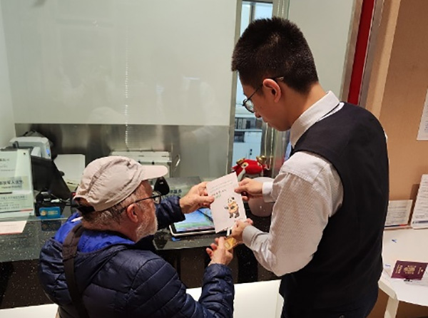 工作人員為外籍來渝人員講解相關業(yè)務辦理流程。浦發(fā)銀行重慶分行供圖