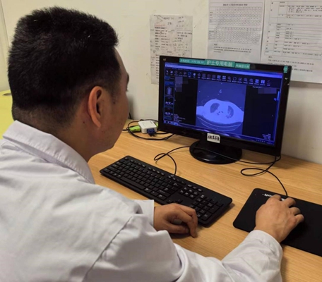 王曉龍查看患者的肺部CT檢查結果。重慶醫(yī)科大學附屬第二醫(yī)院供圖