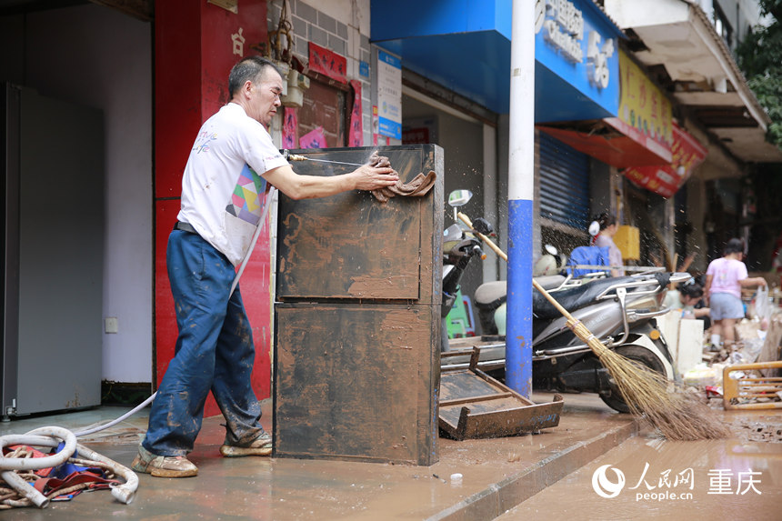 洪水消退后，居民正在清洗被洪水浸過的物品。人民網(wǎng)記者 劉政寧攝