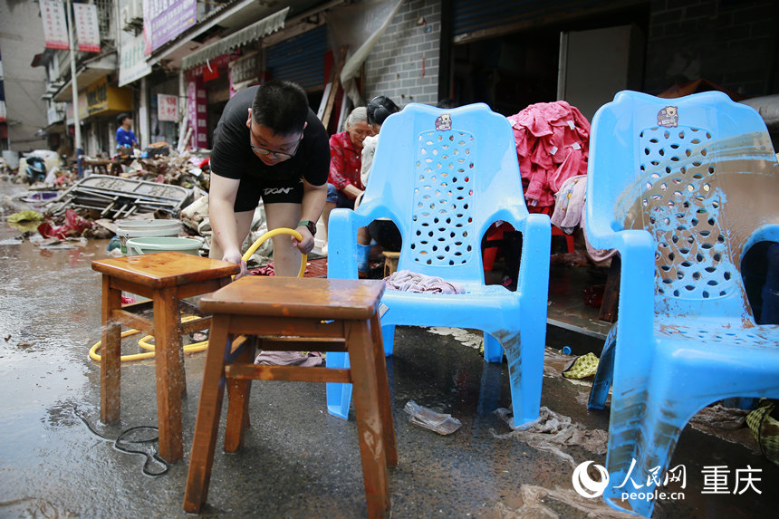 洪水消退后，居民正在清洗被洪水浸過的物品。人民網(wǎng)記者 劉政寧攝