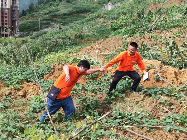 《跋涉》。6月29日，107地質(zhì)隊(duì)的駐守地質(zhì)工程師陳虹洲在彭水巡查雨后的地災(zāi)點(diǎn)時(shí)深陷泥潭，同事王發(fā)英搭手拽他脫離“困境”。李明亮攝