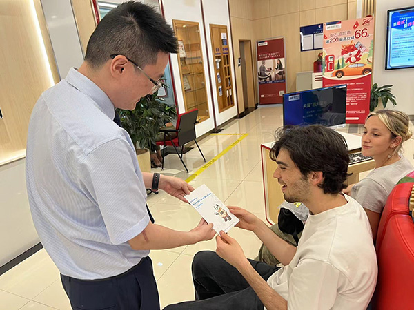 為外籍來華人員發(fā)放雙語宣傳折頁。浦發(fā)銀行重慶分行供圖
