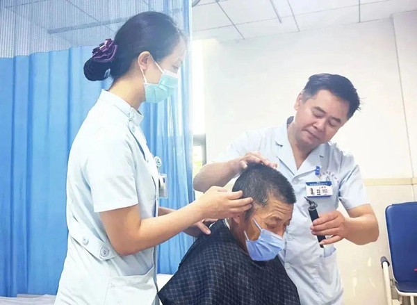 醫(yī)護(hù)為老年患者理發(fā)。重慶合川宏仁醫(yī)院供圖