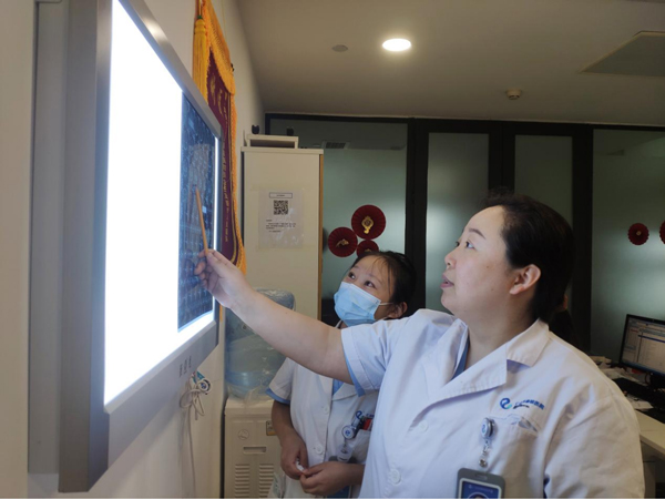 張朝梅查看患者的檢查報(bào)告。重慶仁品耳鼻喉醫(yī)院供圖