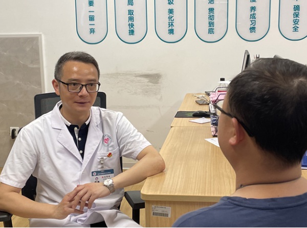 陳黎明正在與患者溝通。重慶市精神衛(wèi)生中心供圖