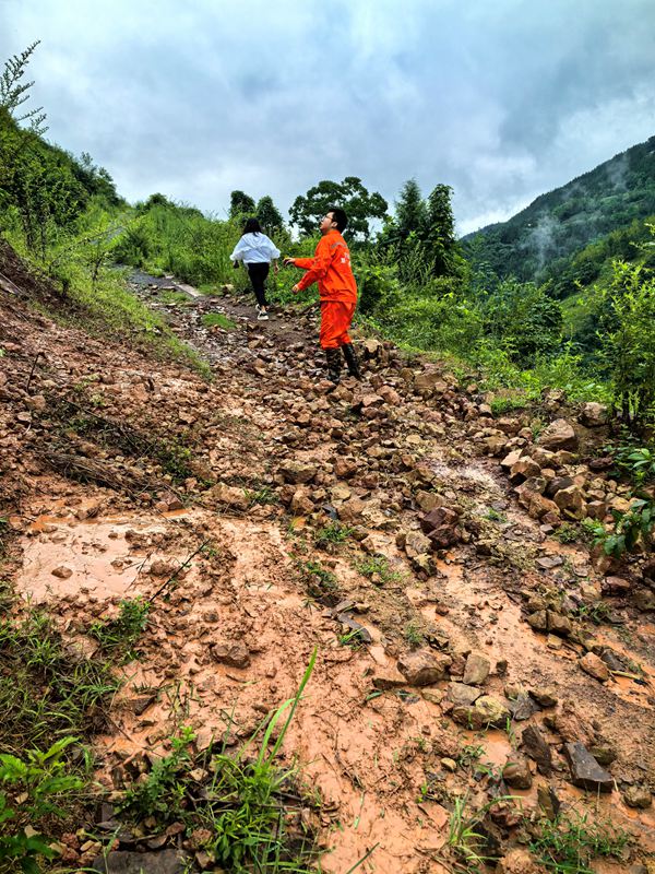 《雨后地災(zāi)巡查》。7月11日，巫山縣銅鼓鎮(zhèn)副鎮(zhèn)長溫利華、地質(zhì)駐守工程師王忠凌（右）雨后巡查銅鼓村柏果樹坪地災(zāi)點(diǎn)。劉勇攝