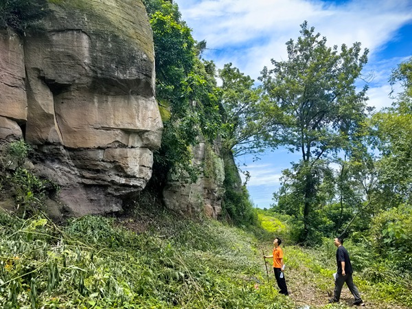 《與巨石對(duì)話》。6月21日，川東南勘察公司合川駐守地質(zhì)工程師袁少游（左）、譚韜對(duì)合川區(qū)石泉后山危巖進(jìn)行雨后核查。竹越攝