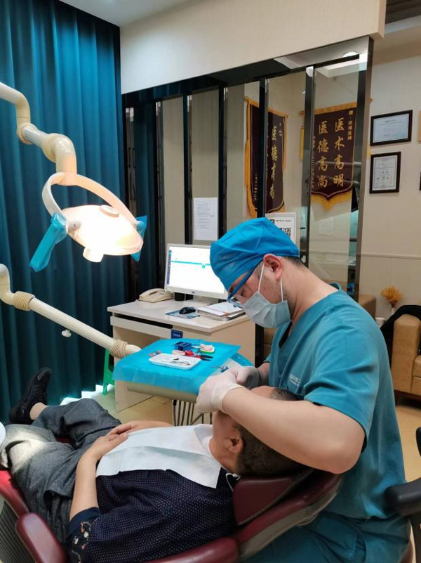醫(yī)生為患者檢查。泰康拜博口腔供圖