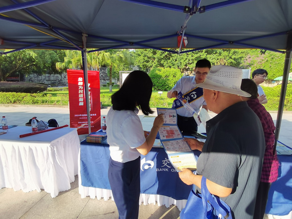 工作人員向市民發(fā)放宣傳資料，宣講金融知識。交行重慶市分行供圖