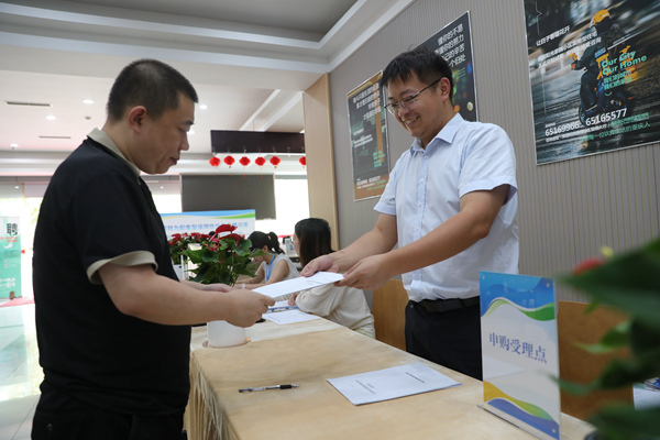 美麗陽光家園公租房購房者關(guān)先生拿到公租房轉(zhuǎn)為配售型保障性住房買賣合同。重慶市住房城鄉(xiāng)建委供圖