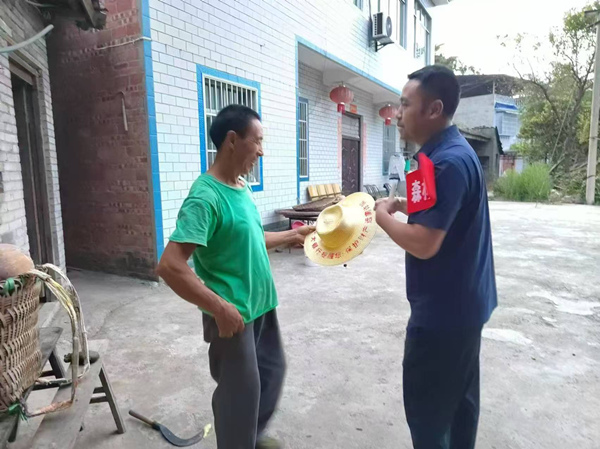 光大銀行重慶分行駐奉節(jié)縣長凼村駐村書記向村民贈(zèng)送印有防詐宣傳語的農(nóng)用草帽。光大銀行重慶分行供圖