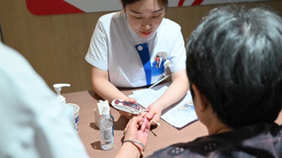 護士為老年患者測血糖。重慶南坪愛爾眼科醫(yī)院供圖