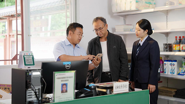 楊聰指導(dǎo)村民辦理相關(guān)業(yè)務(wù)。郵儲銀行重慶分行供圖