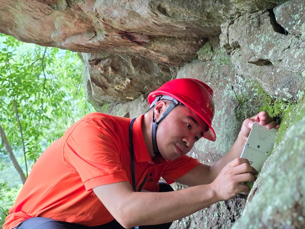 《專注》。7月3日，南江地質(zhì)隊地質(zhì)工程師陳昊在開州區(qū)麻柳鄉(xiāng)調(diào)查危巖。劉黎攝