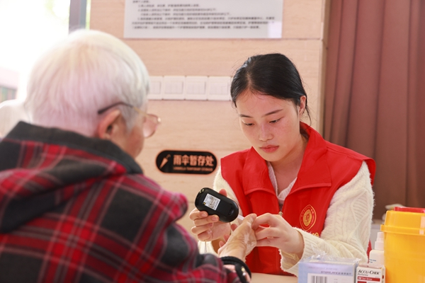 義診中，志愿者為老年人做血糖檢測(cè)。曾英豪攝