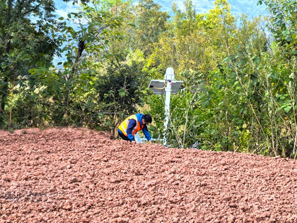 《巡查檢查監(jiān)測儀器（組圖）》。10月4日，王忠凌在日常巡查中，檢查地災點的監(jiān)測儀器是否正常工作。只有做好了日常維護，才能確保告警的準確度。劉勇攝