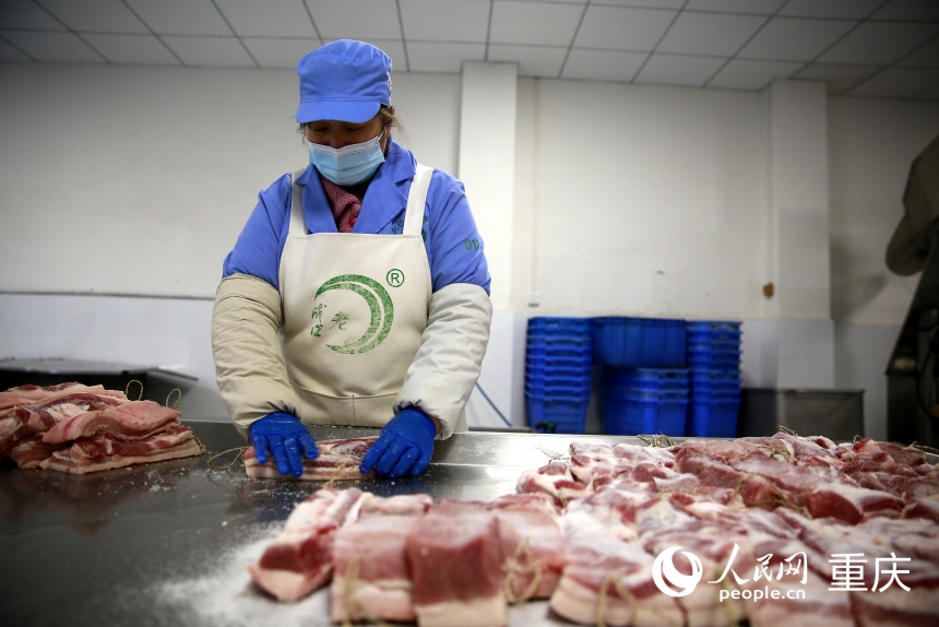 工人手工對(duì)分割好的豬肉進(jìn)行碼鹽。人民網(wǎng)記者 劉政寧攝