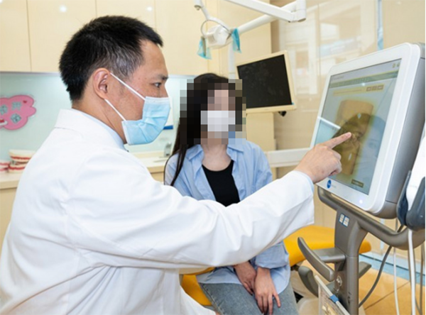 醫(yī)生為患者講解牙齒情況。泰康拜博口腔供圖