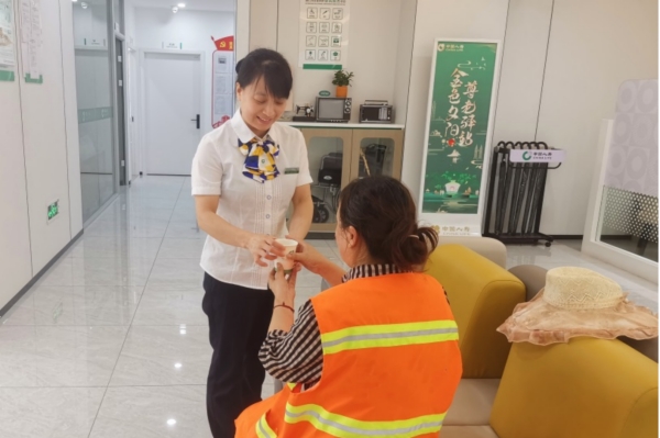 柜面工作人員為環(huán)衛(wèi)工人送清涼。中國人壽壽險重慶市分公司供圖