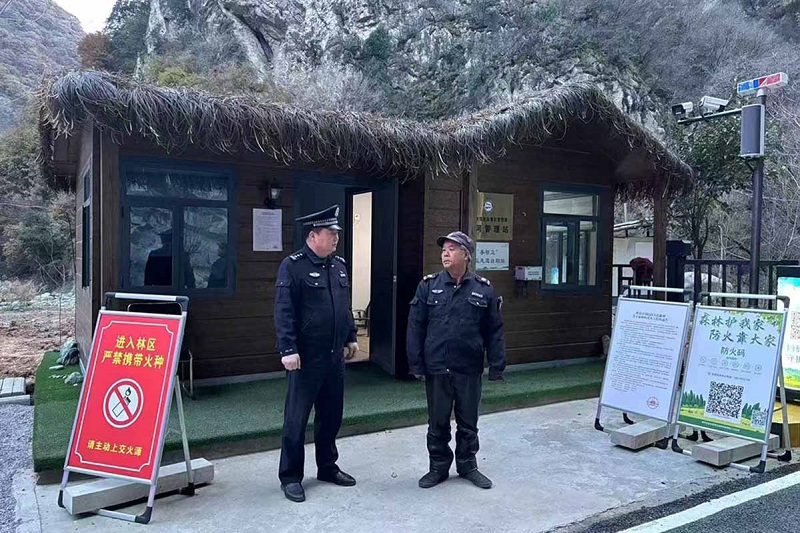 溫軍文（左）在和秦嶺聯(lián)防的民間工作人員交談。李凱攝