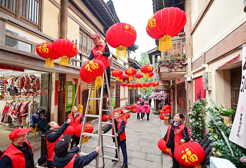 志愿者為黃葛古道敦厚坡老街的傳統(tǒng)民居掛燈籠。郭旭攝