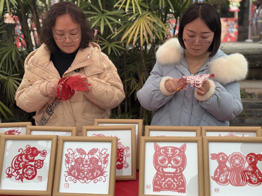 袁誼、趙俊教孩子們剪紙。黃亞輝攝