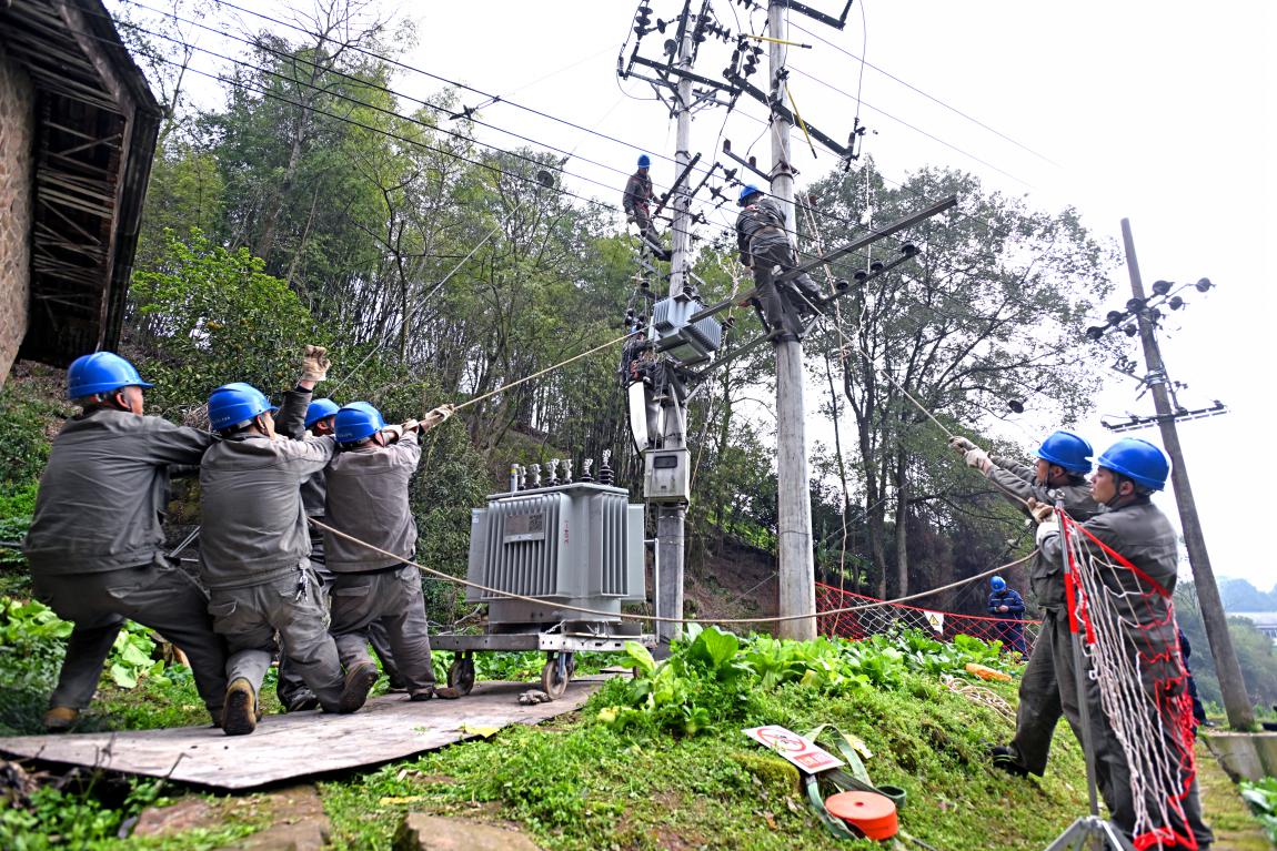 國網(wǎng)重慶市北供電公司員工為高竹新區(qū)增容變壓器，保障春耕春灌可靠用電。向江微攝