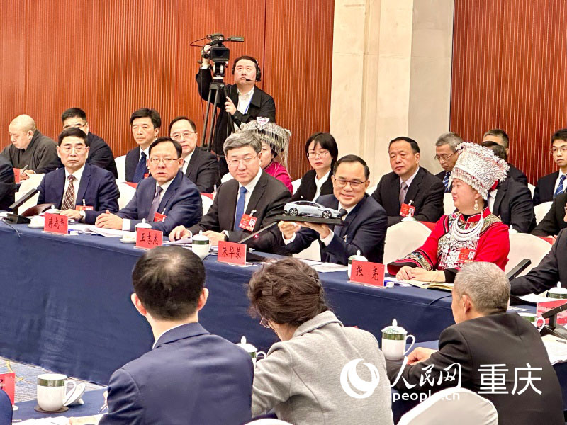 2025全國兩會期間，朱華榮在重慶代表團(tuán)開放團(tuán)組會議上展示“重慶造”汽車模型。人民網(wǎng)記者 劉政寧攝