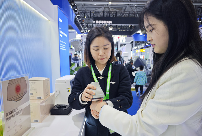 工作人員展示超聲波關(guān)節(jié)按摩儀。重慶海扶醫(yī)療供圖