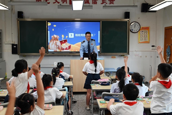 渝中區(qū)稅務(wù)人員走進馬家堡小學(xué)六年級6班，與同學(xué)們共上“稅法一堂課”，課堂上同學(xué)們踴躍舉手發(fā)言。徐佑君攝