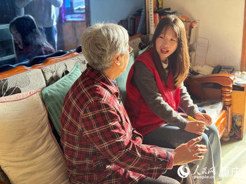 陳春林（右）在居民家中入戶走訪。人民網(wǎng)記者 胡虹攝