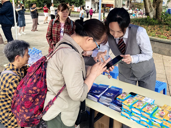 工作人員指導(dǎo)老人使用手機(jī)。重慶電信供圖