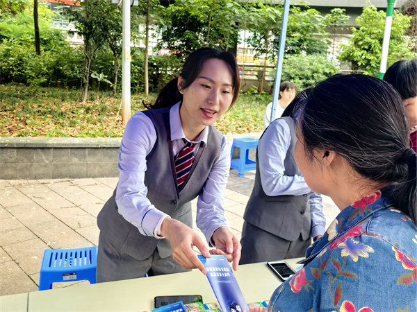 工作人員向老人發(fā)放反詐手冊(cè)。重慶電信供圖