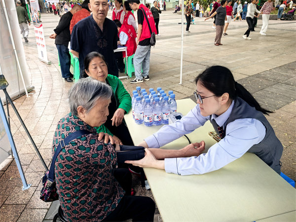 工作人員為老人測(cè)量血壓。重慶電信供圖