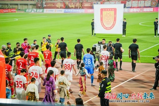 銅梁龍隊(duì)員與昌都孩子攜手入場(chǎng)。重慶銅梁龍足球俱樂(lè)部供圖