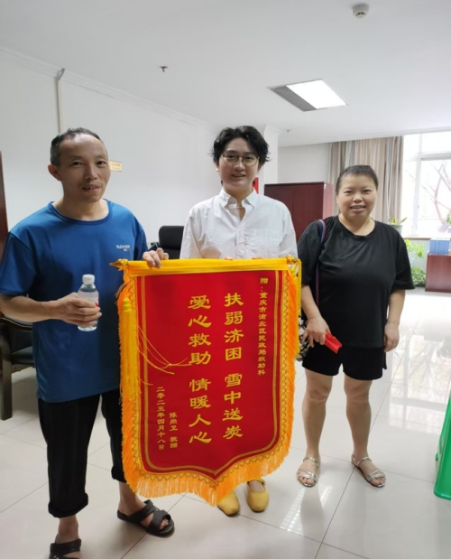 陳尚衛(wèi)為渝北區(qū)民政局救助科工作人員送上錦旗。渝北區(qū)民政局供圖