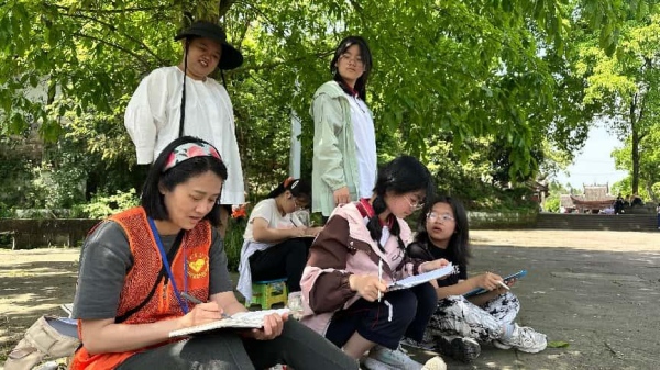 志愿者帶領(lǐng)游客親手描繪石刻。大足石刻研究院供圖