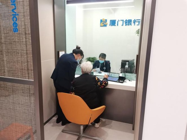 工作人員引導(dǎo)老年群體辦理相關(guān)業(yè)務(wù)。廈門銀行重慶分行供圖